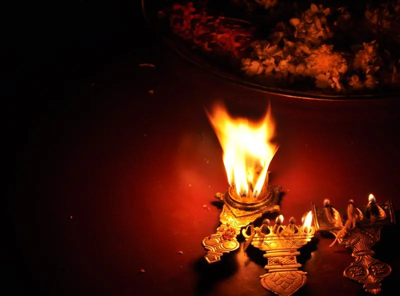 Glowing traditional brass diya oil lamp illuminated at sacred morning home altar